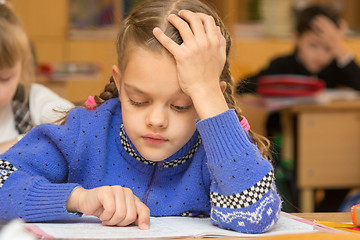 Image showing First-grader at a lesson reads the text, running his finger along the lines