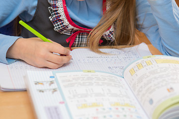 Image showing A pupil in class writing in a notebook, close-up