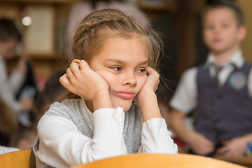 Image showing Girl bored at school sitting at a desk on the reverse