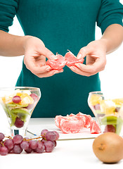 Image showing Cook is peeling grapefruit for fruit dessert