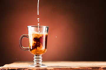 Image showing Adding milk to a cup of coffee.