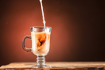 Image showing Adding milk to a cup of tea