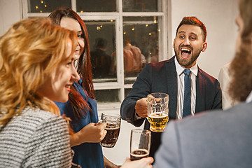 Image showing Group of friends enjoying evening drinks with beer