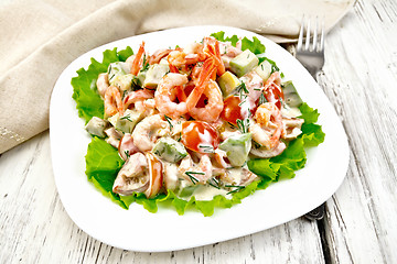 Image showing Salad with shrimp and avocado in white plate on light board