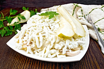 Image showing Salad of squid and pears with fork on board