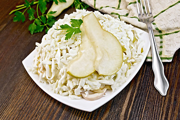 Image showing Salad of squid and pears with parsley on dark board