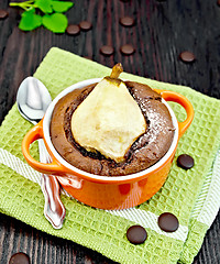 Image showing Cake chocolate with pear in red bowl on green napkin