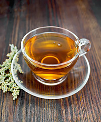 Image showing Tea with wormwood in glass cup on board