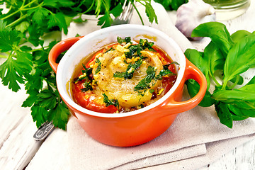 Image showing Fish baked with tomato and basil in red pot on board