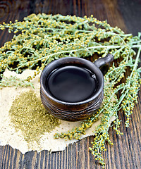 Image showing Tea with wormwood in cup on dark board