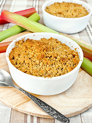 Image showing Crumble rhubarb in white bowl on linen tablecloths