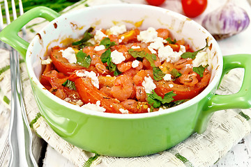 Image showing Shrimp and tomato with feta in green pan on light board