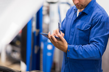 Image showing auto mechanic with clipboard at car repair shop