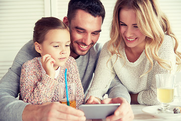 Image showing happy family with smartphone at restaurant