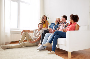 Image showing happy friends with popcorn and beer at home