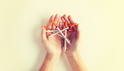 Image showing close up of woman hands holding syringes