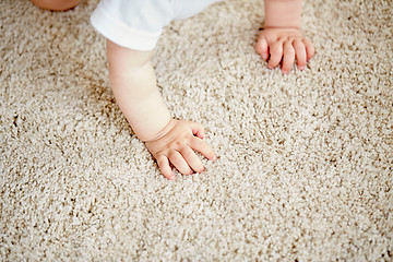 Image showing hands of baby crawling on floor or carpet