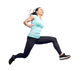 Image showing happy smiling sporty young woman jumping in air