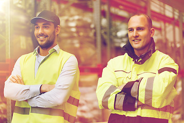 Image showing smiling men in reflective uniform at warehouse