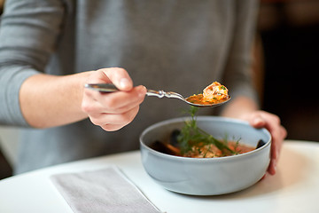 Image showing woman eating fish soup at cafe or restaurant