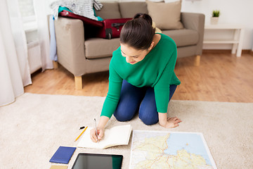 Image showing woman with notebook and travel map at home