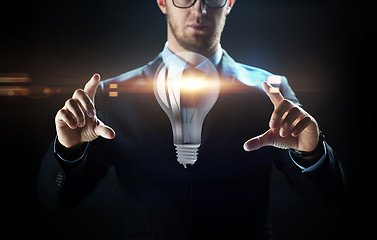 Image showing close up of businessman with lightbulb projection