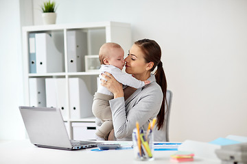 Image showing happy businesswoman with baby and laptop at office