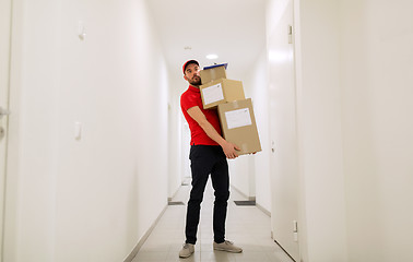 Image showing delivery man with parcel boxes in corridor