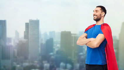 Image showing happy man in red superhero cape over city