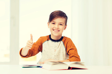 Image showing happy student boy with textbook showing thumbs up