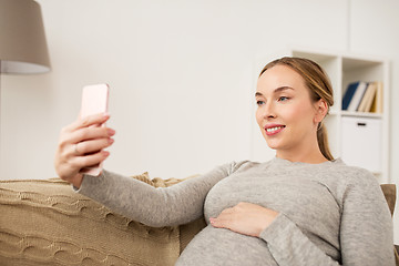 Image showing pregnant woman taking smartphone selfie at home