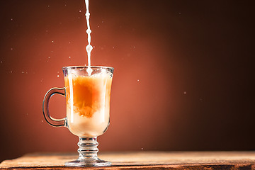 Image showing Adding milk to a cup of coffee.