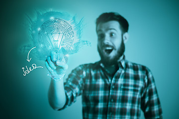 Image showing Handsome young man with idea bulb on blue