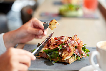 Image showing woman eating prosciutto ham salad at restaurant