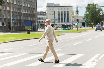 Image showing senior man walking along city crosswalk