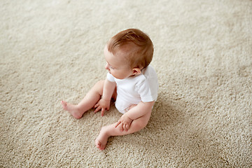 Image showing happy baby boy or girl sitting on floor at home