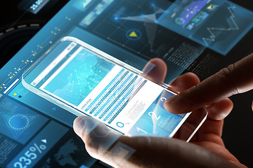 Image showing close up of hands with charts on glass smartphone