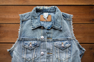 Image showing denim vest or waistcoat on wooden background