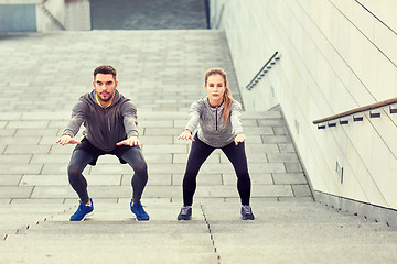 Image showing couple doing squats and exercising outdoors