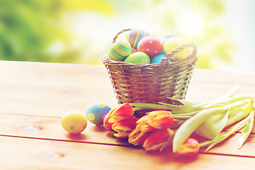 Image showing close up of easter eggs in basket and flowers