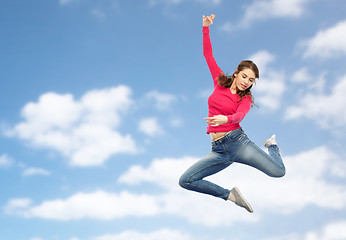 Image showing smiling young woman jumping in air