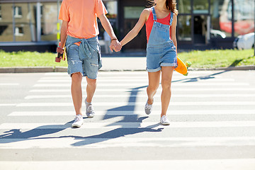 Image showing teenage couple with skateboards on city crosswalk