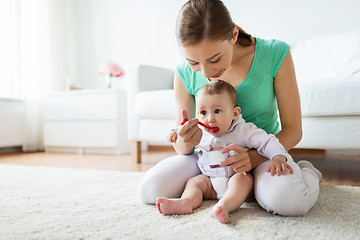 Image showing mother with spoon feeding little baby at home