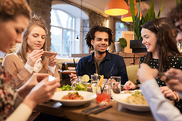 Image showing friends with smartphones eating at restaurant