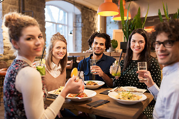 Image showing happy friends eating and drinking at restaurant