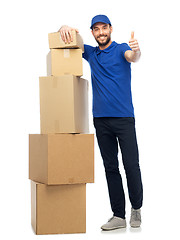 Image showing happy delivery man with boxes showing thumbs up