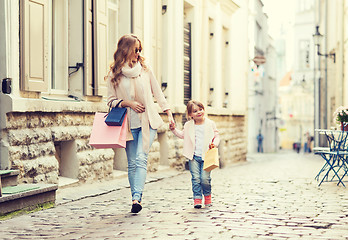 Image showing happy mother and child with shopping bags in city