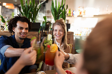 Image showing happy friends clinking drinks at restaurant