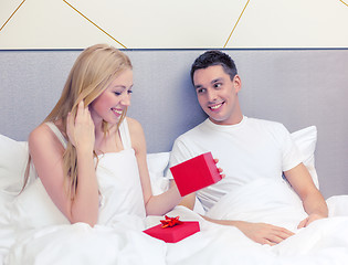 Image showing man giving woman little red gift box