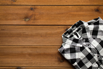 Image showing close up of checkered shirt on wooden background